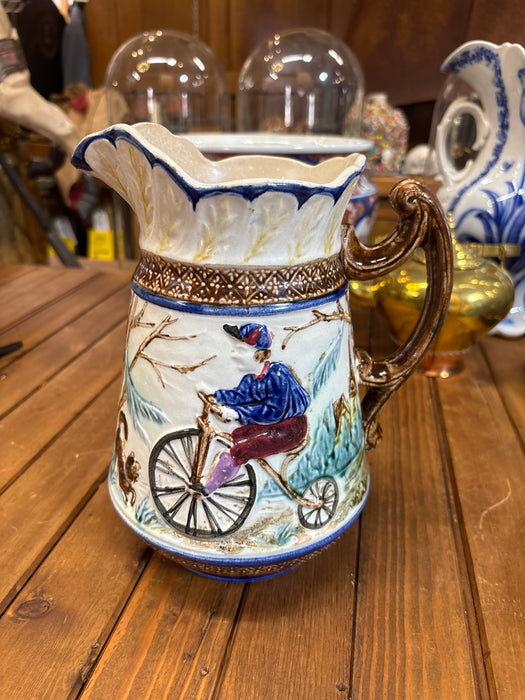 MAJOLICA PITCHER WITH BICYCLER