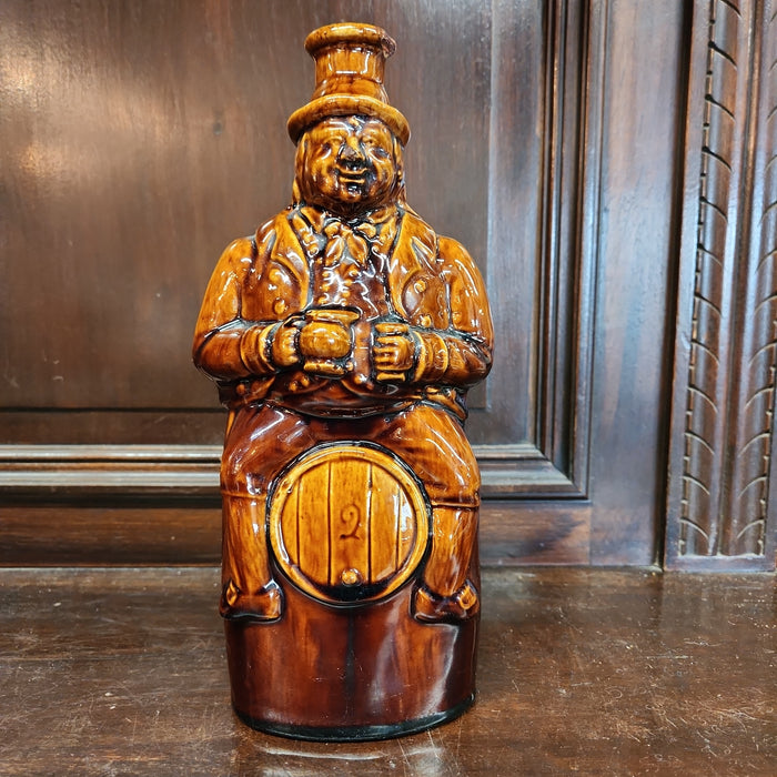 MAN ON BARREL POTTERY BOTTLE
