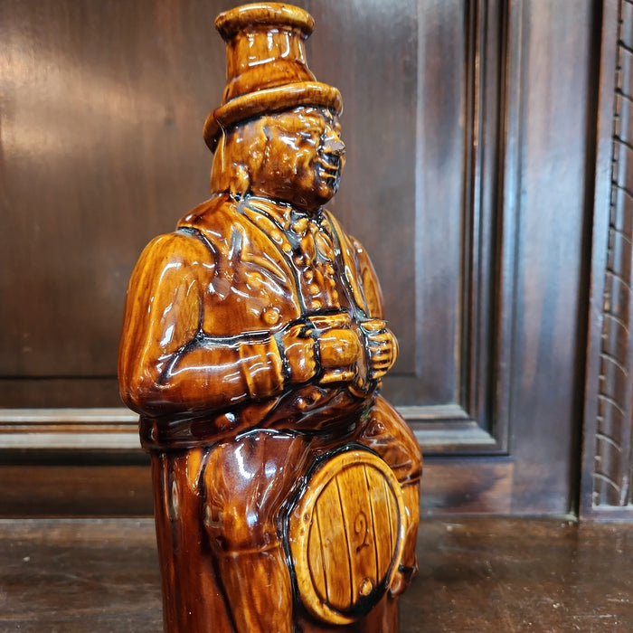 MAN ON BARREL POTTERY BOTTLE