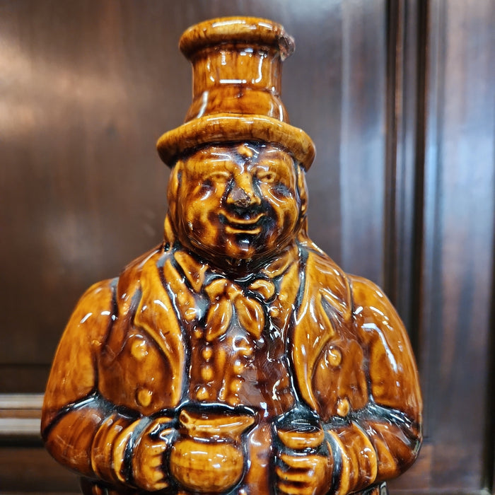 MAN ON BARREL POTTERY BOTTLE