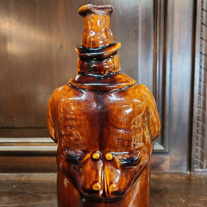 MAN ON BARREL POTTERY BOTTLE