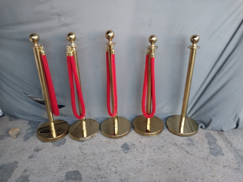 FIVE VINTAGE BRASS RED CARPET STANCHEONS