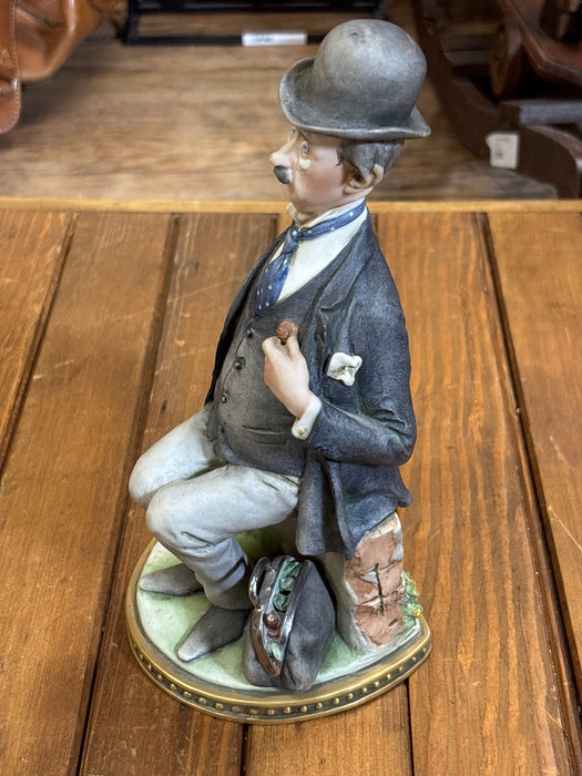 ITALIAN STATUE OF MAN SITTING ON BRICK WALL IN SUIT