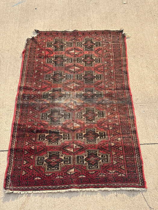 SMALL RED AND BLACK HAND TIED RUG - AS FOUND