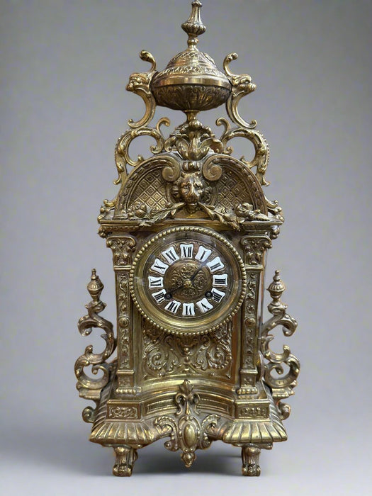 BRASS MANTLE CLOCK WITH GRIFFINS AND LION MASK