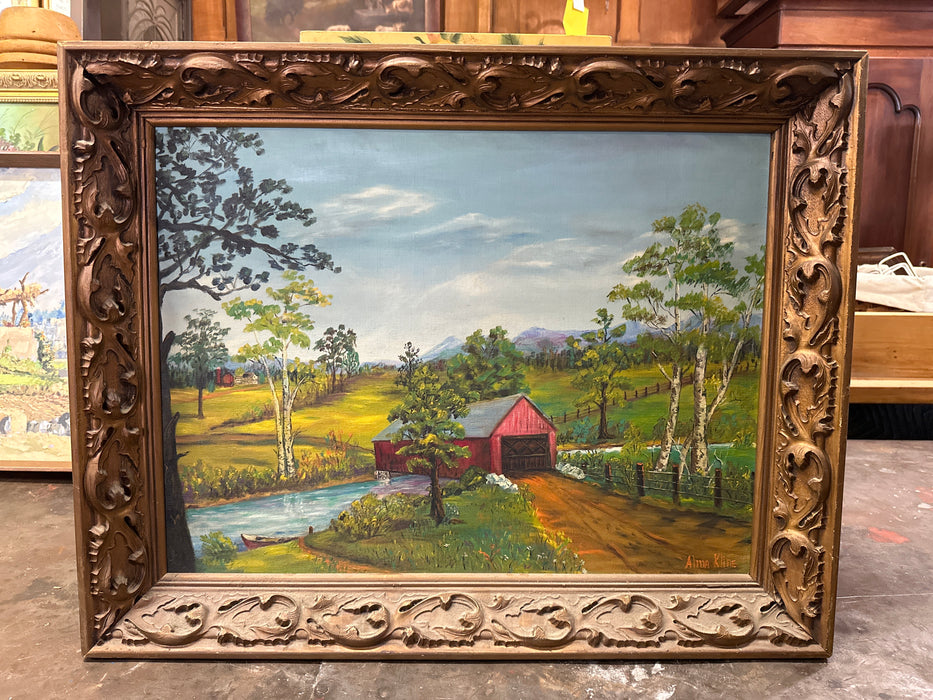CARVED WOOD FRAMED PRIMITIVE OIL PAINTING ON BOARD OF A COVERED BRIDGE