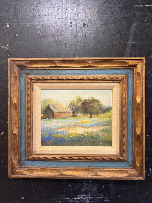 BROWN AND BLUE FRAMED OIL PAINTING OF BARN AND BLUE BONNETS WITH LINEN FILET - SIGNED E. M. MOORE