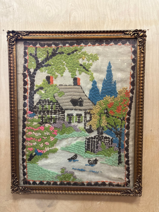 ORNATE GILT FRAMED EMBROIDERY OF HOUSE IN WOODS - AS FOUND