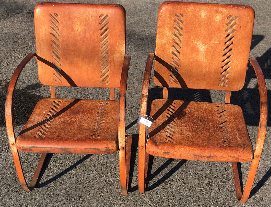 PAIR OF RUST COLORED ROCKING PIERCED METAL CHAIRS