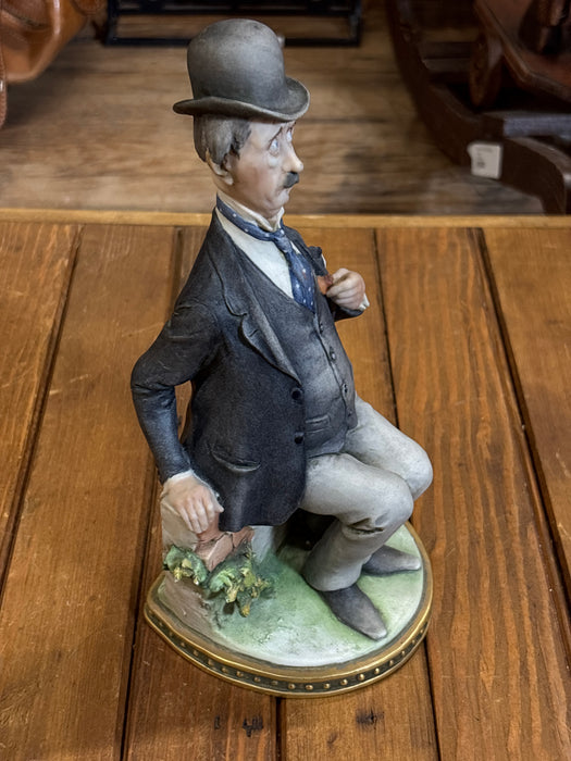 ITALIAN STATUE OF MAN SITTING ON BRICK WALL IN SUIT