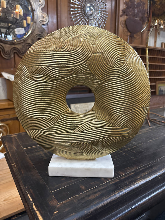 TEXTURED GOLD RING ON MARBLE BASE
