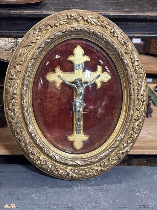 LARGE FOLIATE OVAL GILT FRAMED CRUCIFIX WITH CONVEX GLASS