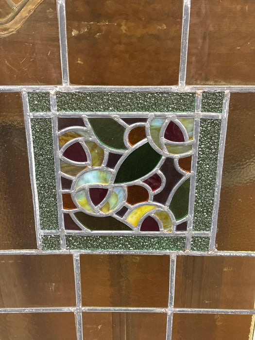 LARGE GREEN STAINED GLASS WINDOW WITH FLORAL CENTER AND THIN WHITE FRAME