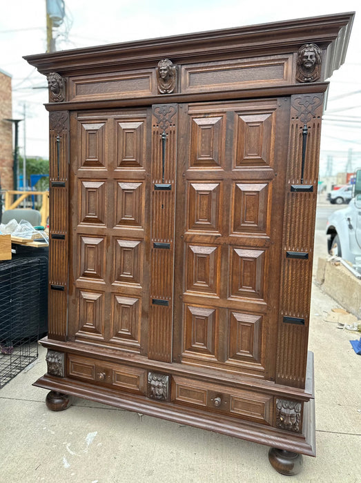 OAK PANELED DOUBLE DOOR ARMOIRE WITH CARVED HEADS