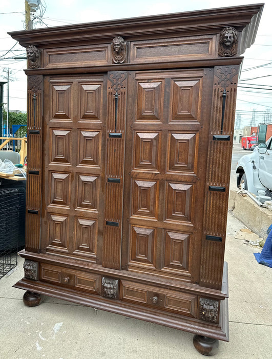 OAK PANELED DOUBLE DOOR ARMOIRE WITH CARVED HEADS