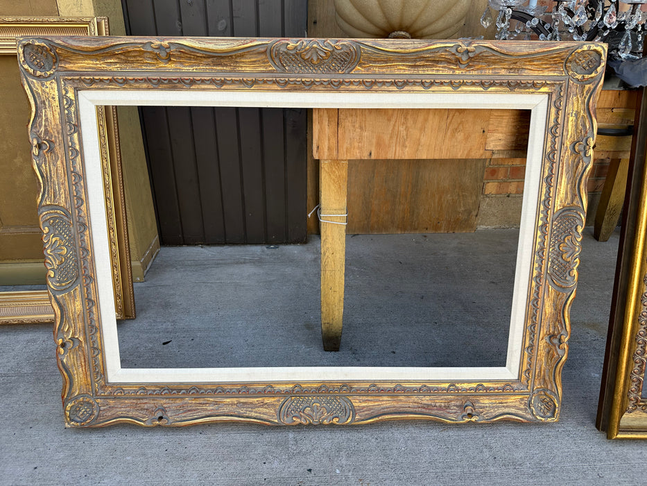 CARVED GILT WOOD FRAME WITH LINEN FILET