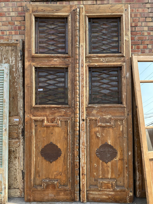 PAIR OF TALL EGYPTIAN IRON INSET PRIMITIVE WOOD DOORS WITH IRON EMBLEMS