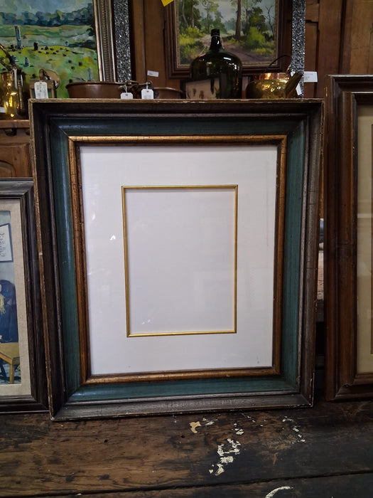 GREEN AND GILT FRAME WITH GLASS AND MAT