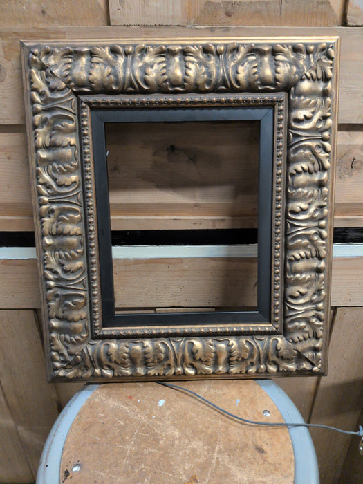 CARVED GILT WOOD FRAME WITH BLACK LINER