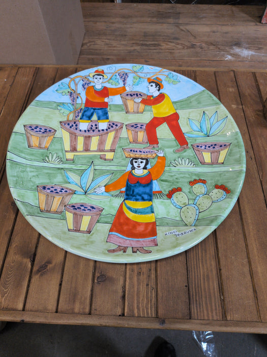 LARGE ITALIAN GLAZED TERRACOTTA CHARGER DEPICTING WINE MAKING