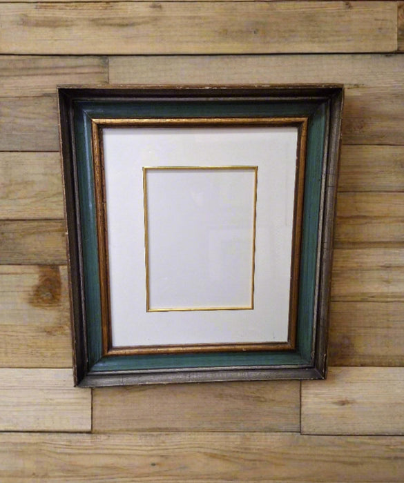 GREEN AND GILT FRAME WITH GLASS AND MAT