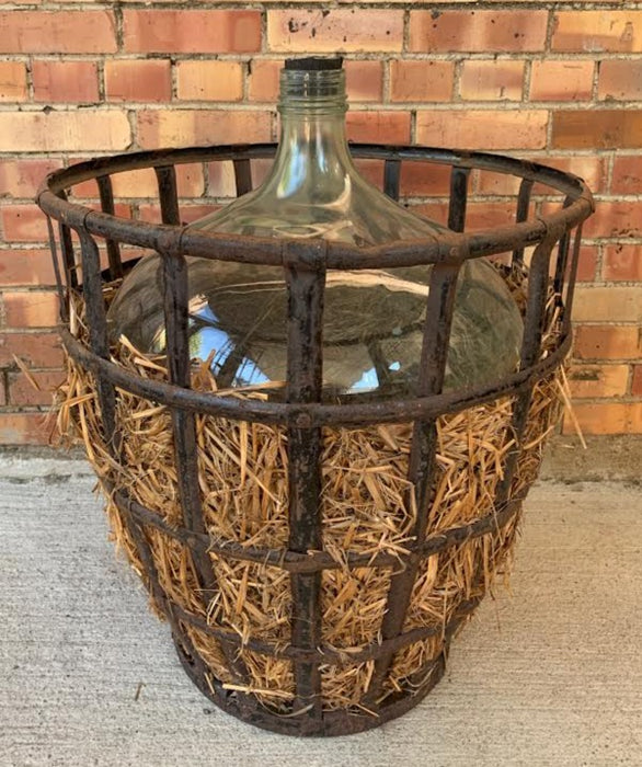 HUGE WINE BOTTLE IN IRON BASKET