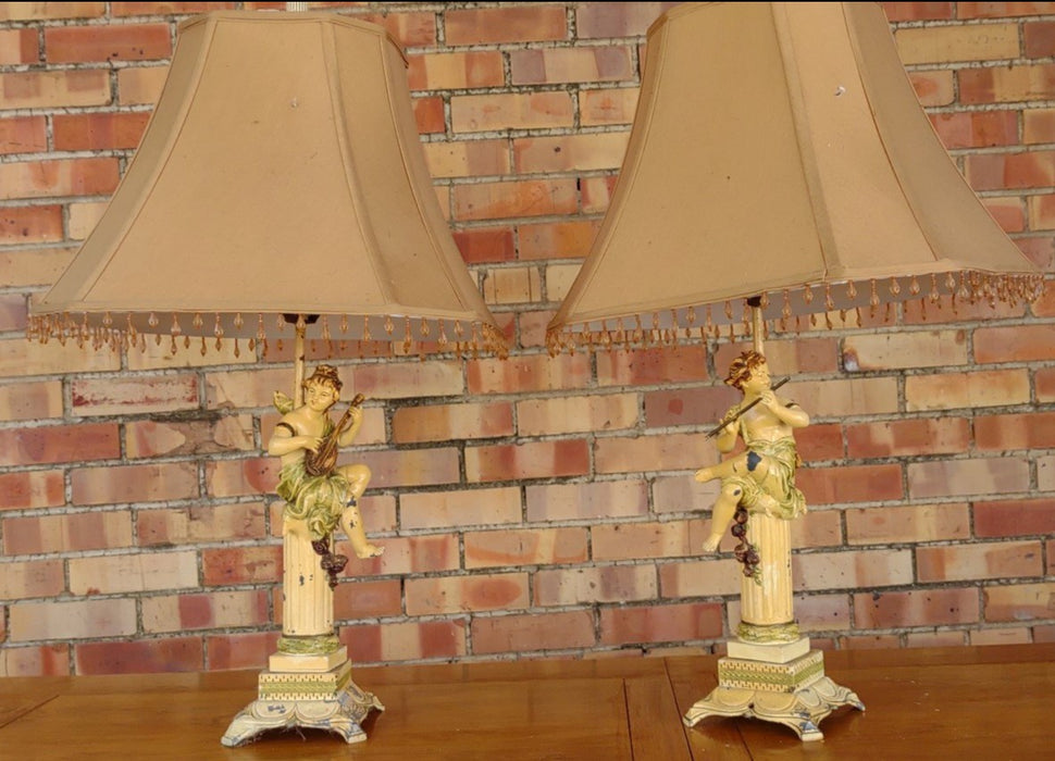 PAIR OF PAINTED METAL CHERUBS WITH INSTUMENTS LAMPS