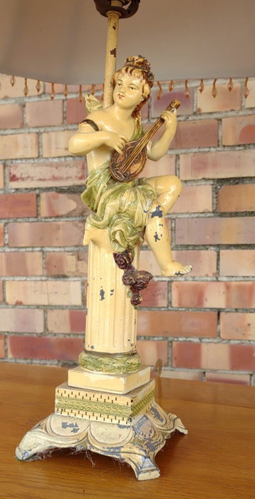 PAIR OF PAINTED METAL CHERUBS WITH INSTUMENTS LAMPS