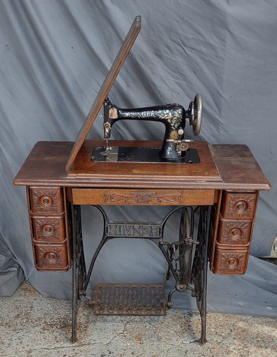 SINGER SEWING MACHINE IN ORIGINAL CARVED OAK CABINET WITH PETAL BASE