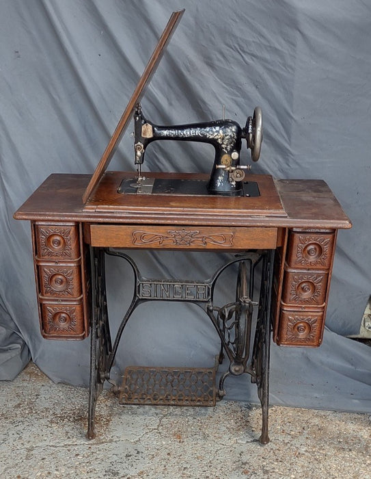 SINGER SEWING MACHINE IN ORIGINAL CARVED OAK CABINET WITH PETAL BASE