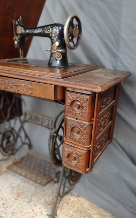 SINGER SEWING MACHINE IN ORIGINAL CARVED OAK CABINET WITH PETAL BASE