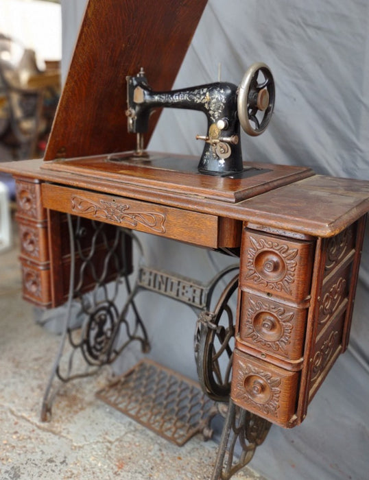 SINGER SEWING MACHINE IN ORIGINAL CARVED OAK CABINET WITH PETAL BASE