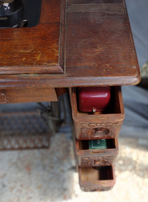 SINGER SEWING MACHINE IN ORIGINAL CARVED OAK CABINET WITH PETAL BASE