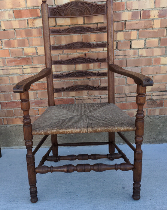 LARGE CHIP CARVED OAK LADDER BACK ARMCHAIR WITH RUSH SEAT AND PEGS