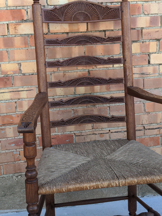 LARGE CHIP CARVED OAK LADDER BACK ARMCHAIR WITH RUSH SEAT AND PEGS