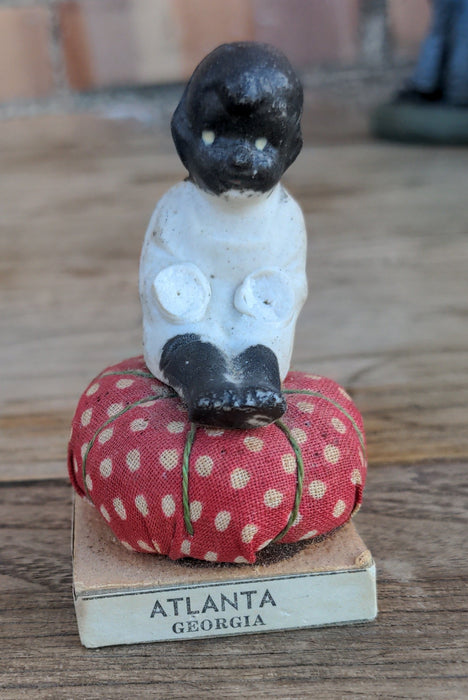 SMALL BLACK MEMORABILIA BABY ON PINCUSHION