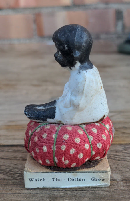 SMALL BLACK MEMORABILIA BABY ON PINCUSHION