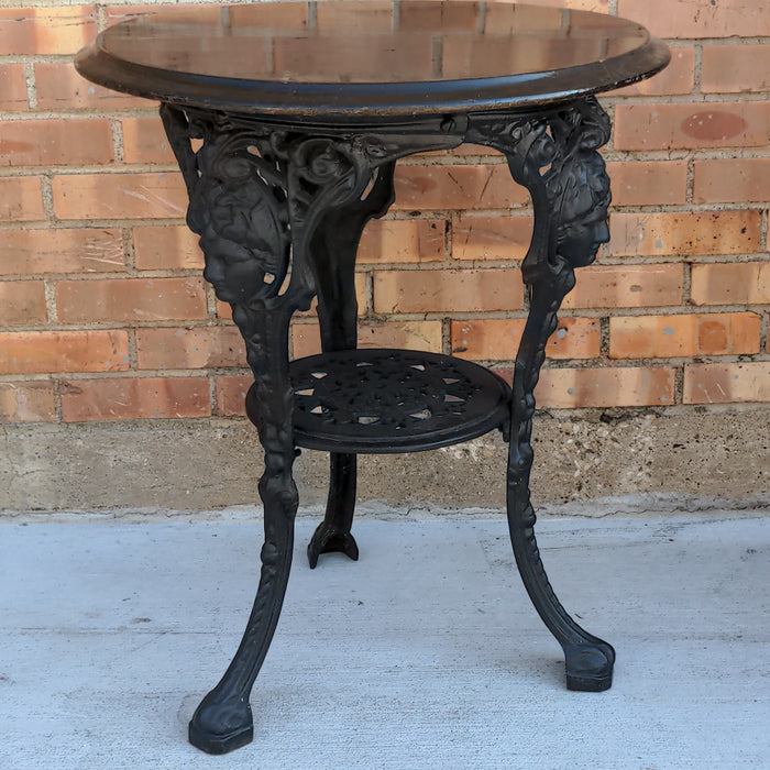 BLACK PAINTED MAHOGANY TOP CAST IRON PUB TABLE WITH FIGURAL MASKS