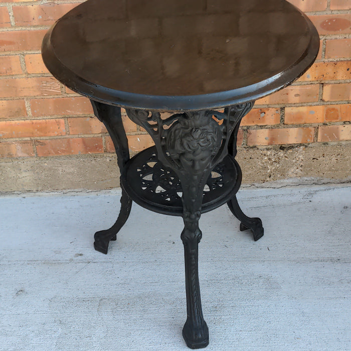 BLACK PAINTED MAHOGANY TOP CAST IRON PUB TABLE WITH FIGURAL MASKS