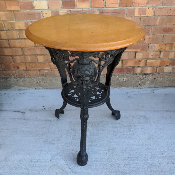 LIGHT MAHOGANY TOP CAST IRON PUB TABLE WITH FIGURAL MASKS