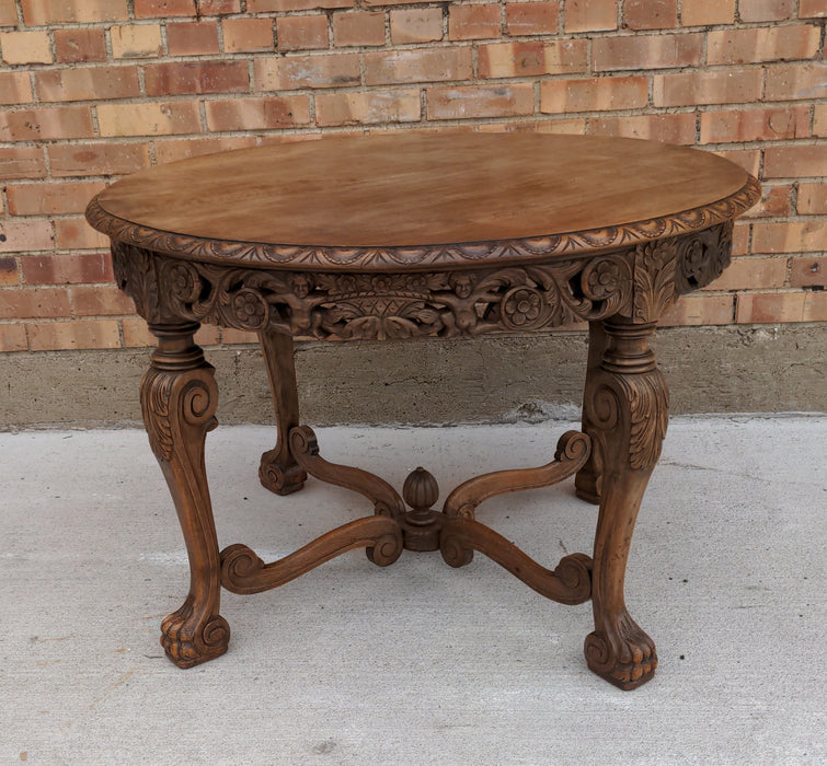 ROUND CARVED OAK LOW OCCASIONAL TABLE, WITH PAW FEET