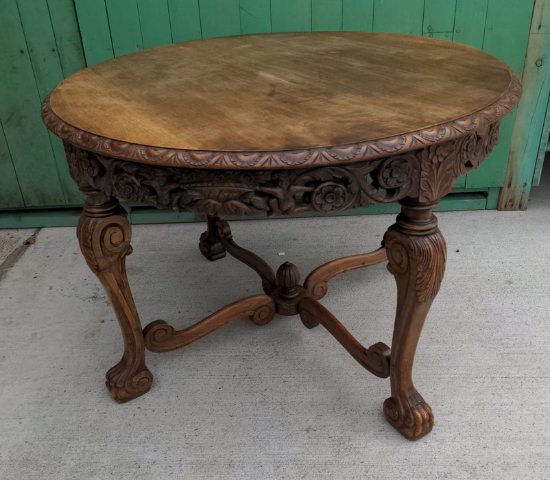 ROUND CARVED OAK LOW OCCASIONAL TABLE, WITH PAW FEET