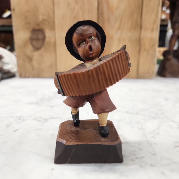 WOOD CARVING OF AN ACCORDIAN PLAYER BOY