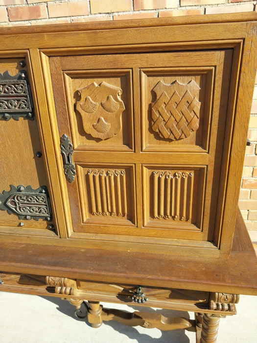 LONG OAK LINENFOLD CABINET WITH IRON STRETCHER AND HANDLES