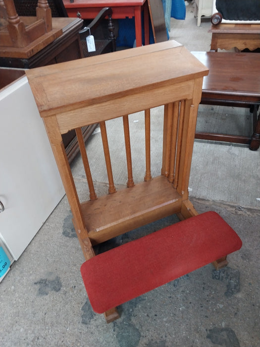 LARGE OAK KNEELER WITH SPINDLES AND RED CUSHION