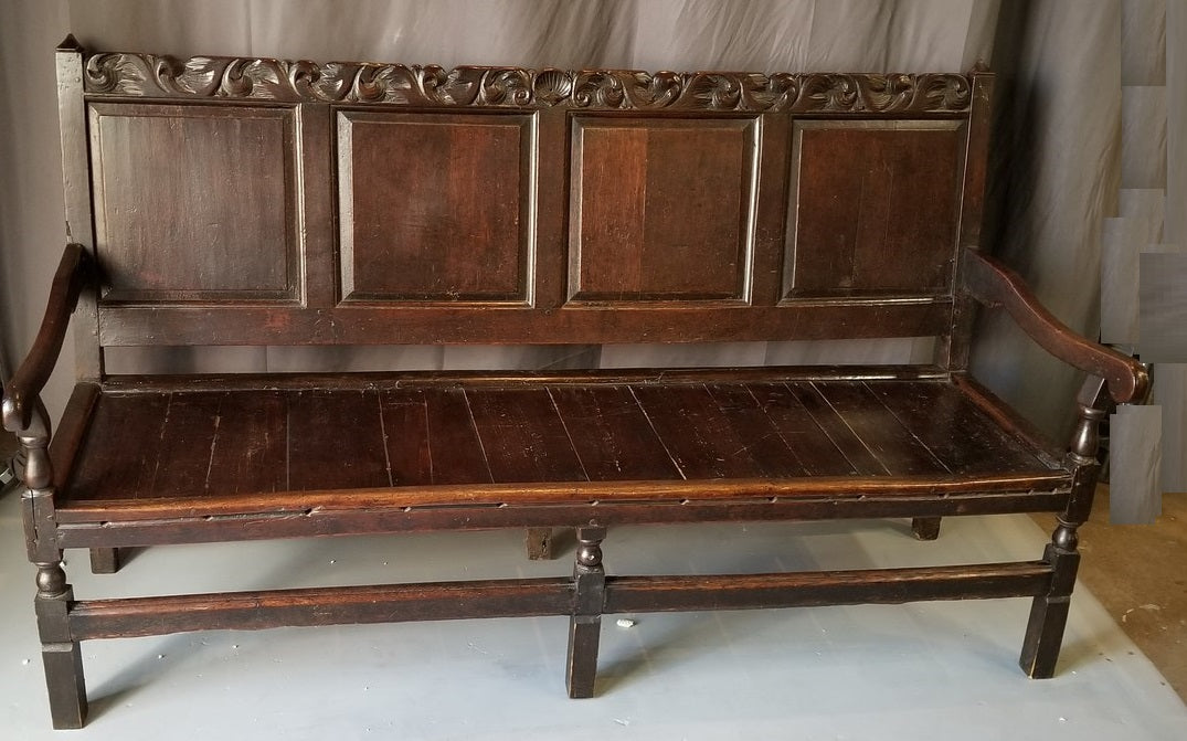 EARLY DARK OAK ENGLISH BENCH WITH ARMS AND A CARVED CREST RAIL