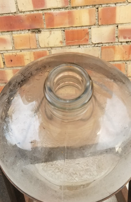 OLD GLASS WATER BOTTLE ON STAND