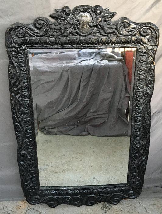 ORNATE SHAPED BLACK MIRROR WITH BEVELED GLASS AND PUTTI PEDIMENT
