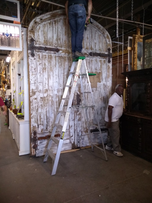 PAIR OF HUGE TURN OF THE CENTURY ANTIQUE ARCHED DOORS FROM BELGIUM WITH STRAP HINGES. 