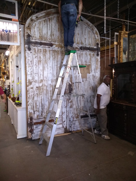 PAIR OF HUGE TURN OF THE CENTURY ANTIQUE ARCHED DOORS FROM BELGIUM WITH STRAP HINGES. 